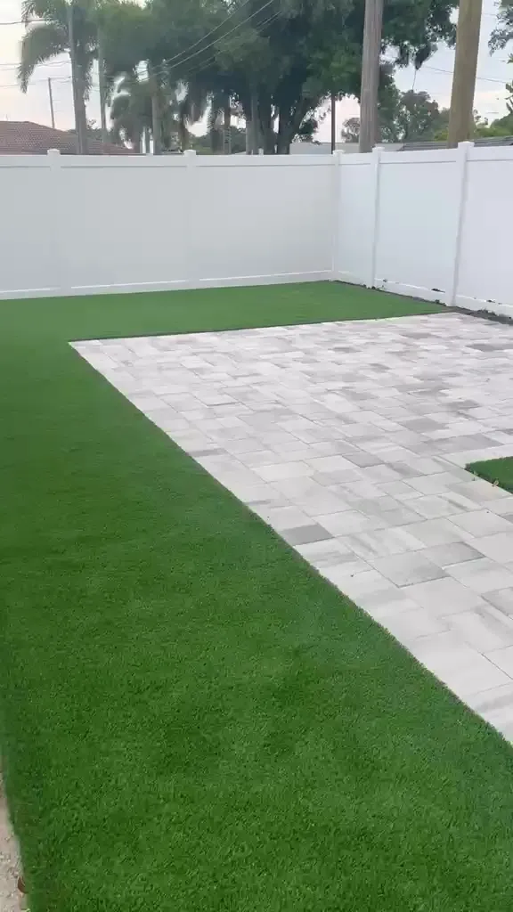 Gray paver patio in a fenced backyard